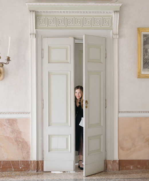 Mindy Weiss looking out from behind a white door