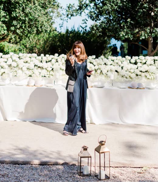 Mindy Weiss in front of a long table of white flowers