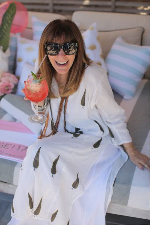 Mindy Weiss smiling, in sunglasses, with a drink