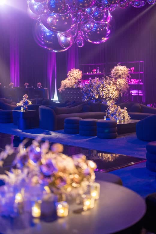 A lounge in purple light under mirrored balls