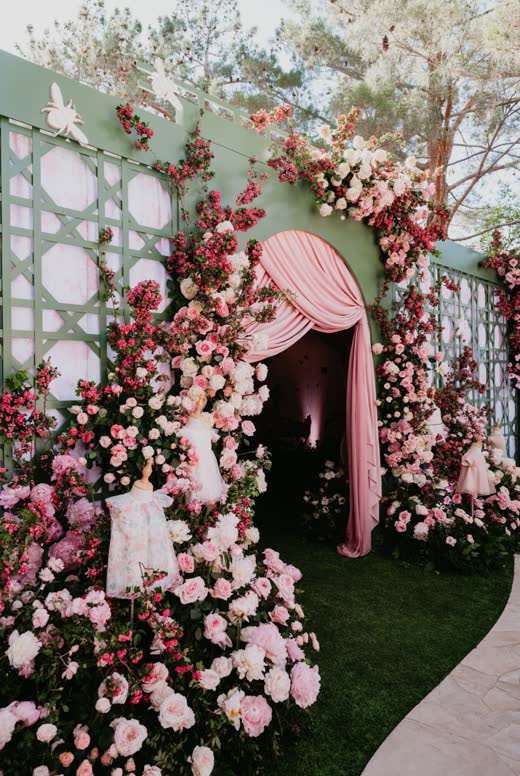 A wall of pink roses and a pink drape at an entrance