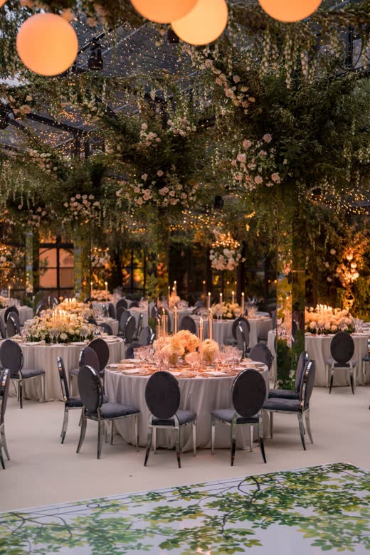 A dinner under the trees with lanterns overhead